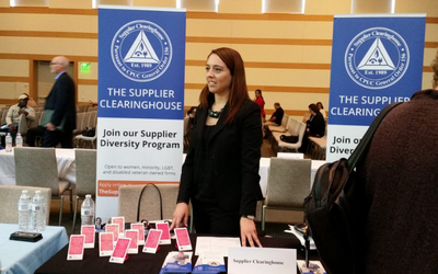 Compliance Manager standing at a outreach event booth