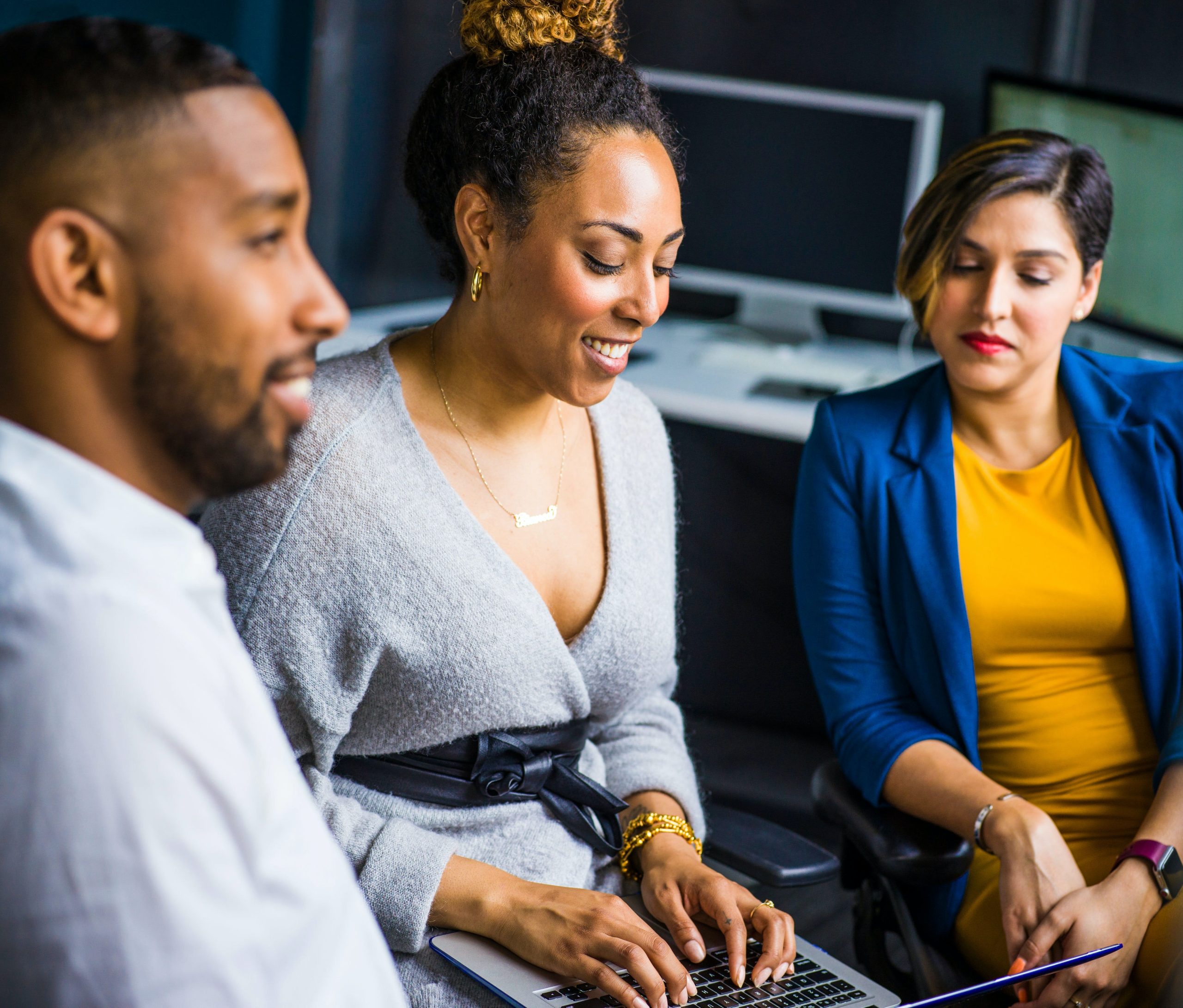 diverse group of people looking at a laptop screen