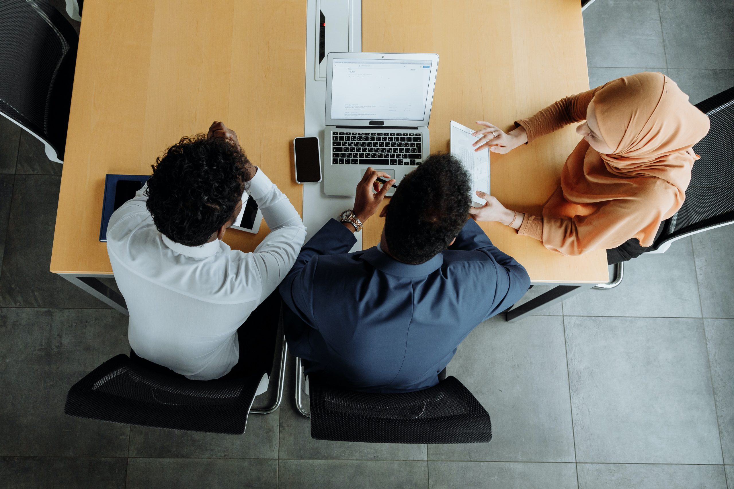 overview of 3 people looking at a laptop